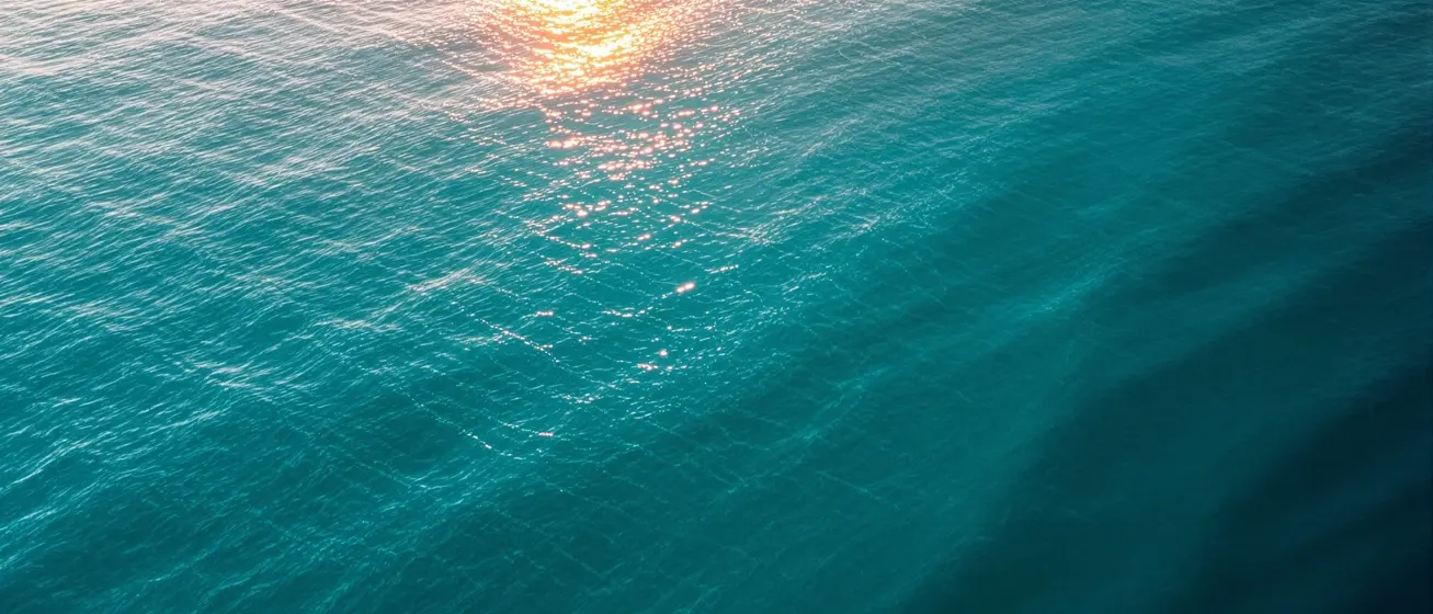 Calm teal ocean water at golden hour representing a gentle, personalized approach to GLP-1 therapy