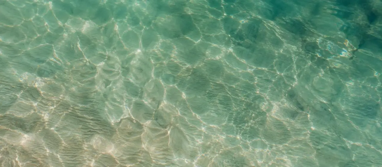 Calm teal ocean water surface photographed from above — compounded GLP-1 weight loss guide